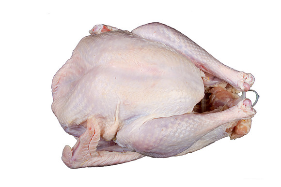 A  close-up view from above of a raw uncooked turkey bird before cooking isolated on a white background.